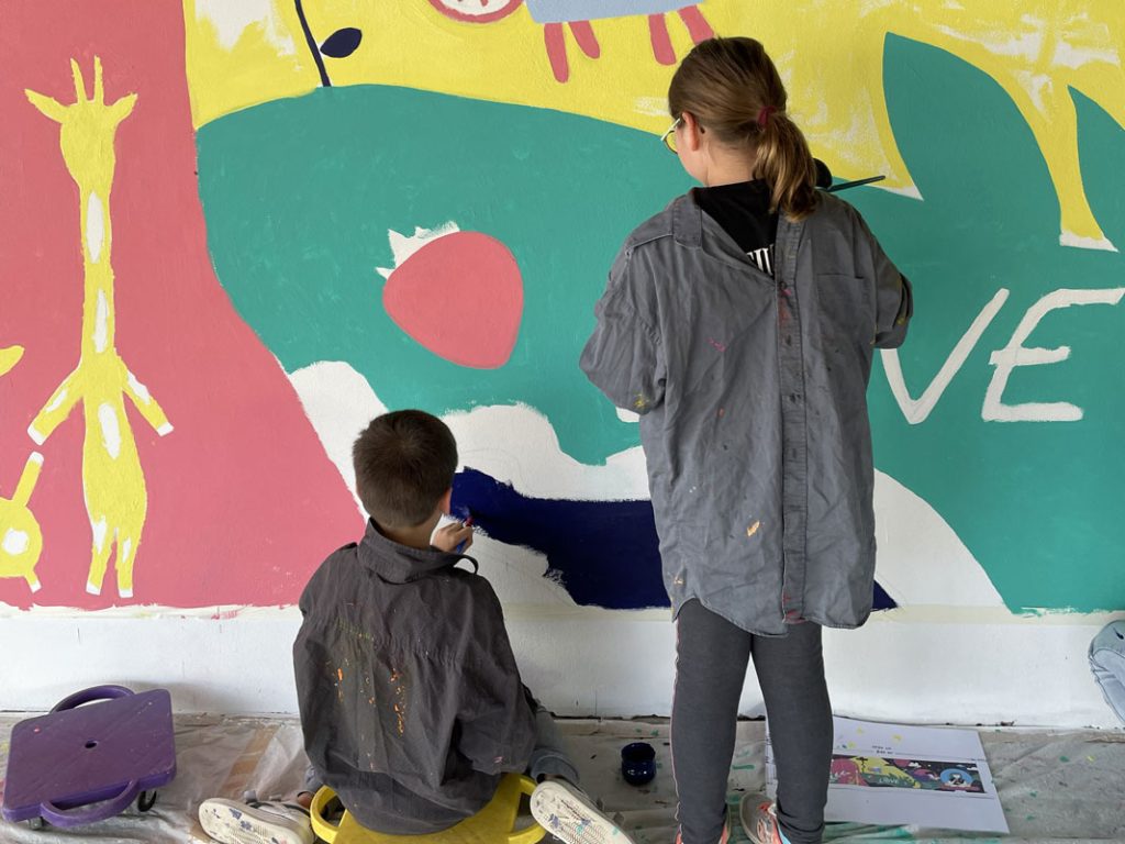 Enfants peignant une fresque sur un mur de cours avec Le Collectif Mélopée